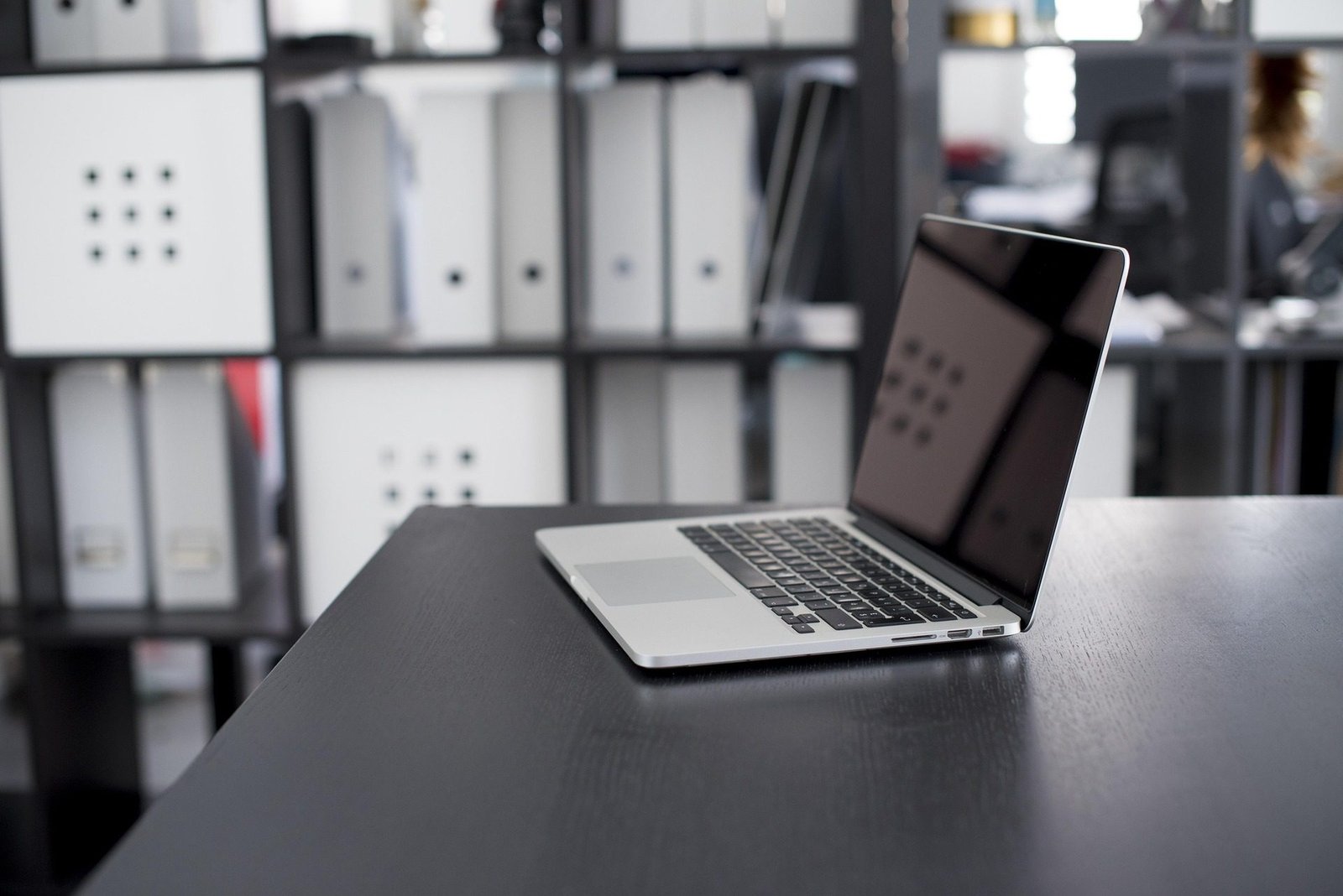 A sleek modern L-shaped desk in a bright UK home office, perfectly utilizing a corner with a dual-monitor setup and ample surface area.